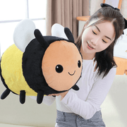 young woman playing with cute kawaii chonky bee plushie with wings and black and yellow stripes
