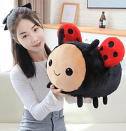 young woman playing with cute kawaii chonky squishy ladybug insect plushie with red wings and black spots